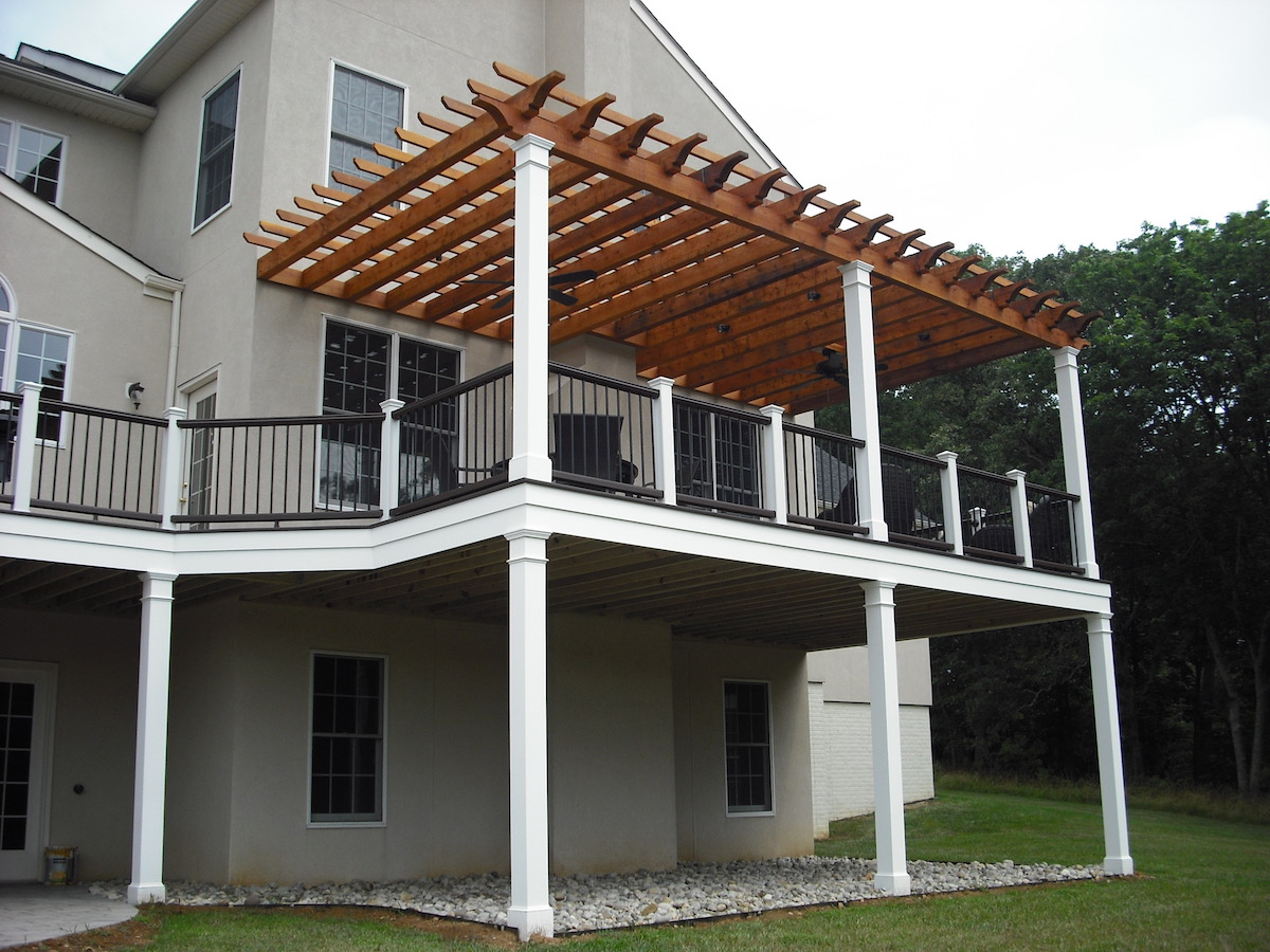 custom deck in northern virginia with a pergola on top and white beams