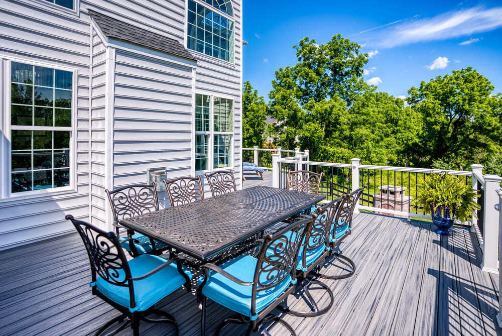 Outdoor table on raised Trex deck with Versatex trim by Deckscapes of Virginia