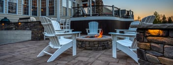 Backyard patio by Deckscapes of Virginia with fire pit next to pool and four chairs at fire pit