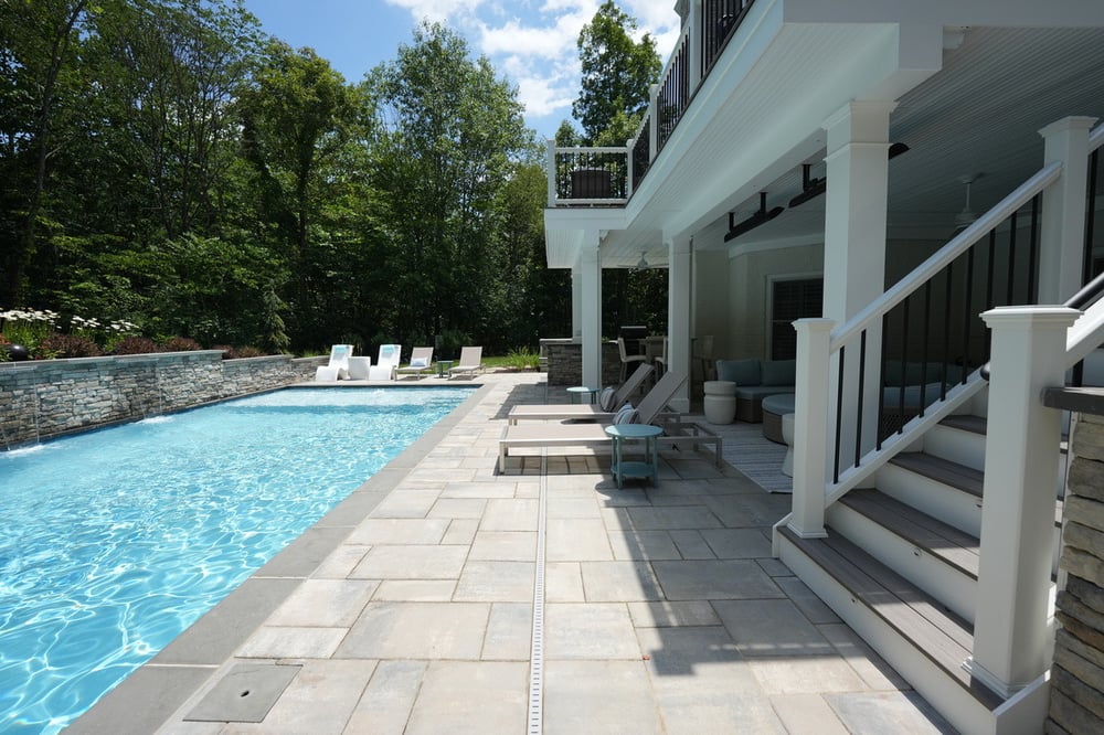 Patio surrounding pool in Northern Virginia by Deckscapes of VA with stairs to raised deck