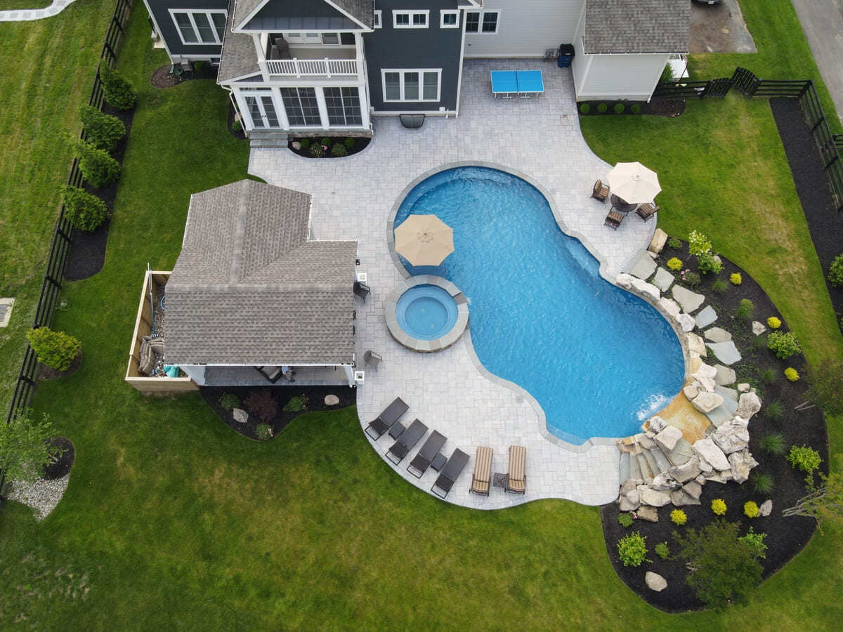 Northern VA outdoor living space with pool, pool house, and patio by Deckscapes of VA