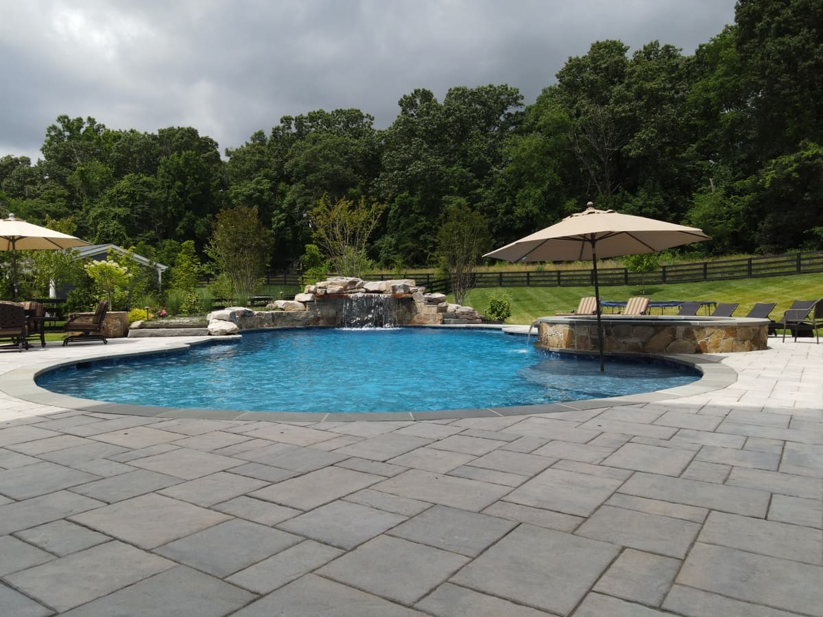 Northern Virginia pool area with waterfall and natural stone coping by Deckscapes of VA