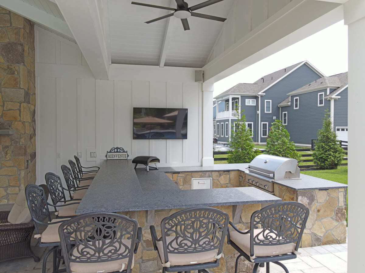 Northern Virginia pool house with outdoor kitchen and bar seating by Deckscapes of VA