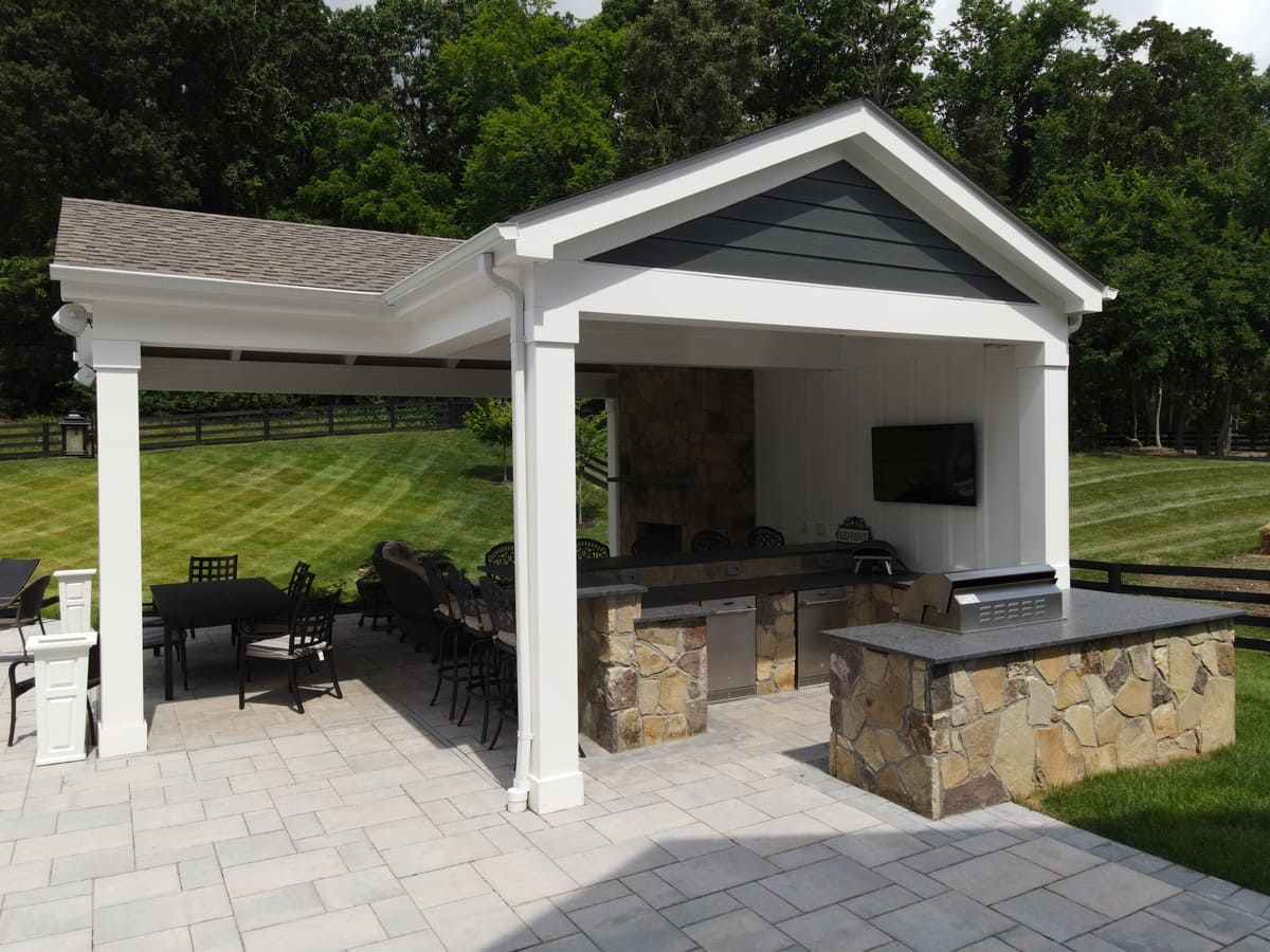 Pool house with outdoor kitchen and stone countertops in Northern Virginia by Deckscapes of VA