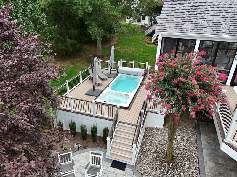 Blooming trees near deck and built-in spa by Deckscapes of VA