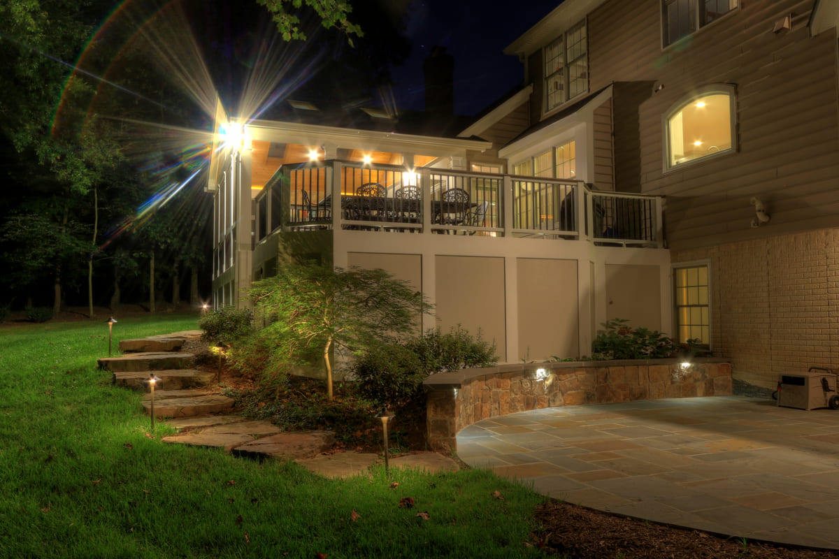 Chantilly, VA patio and steps leading to deck at night with custom lighting by Deckscapes of Virginia