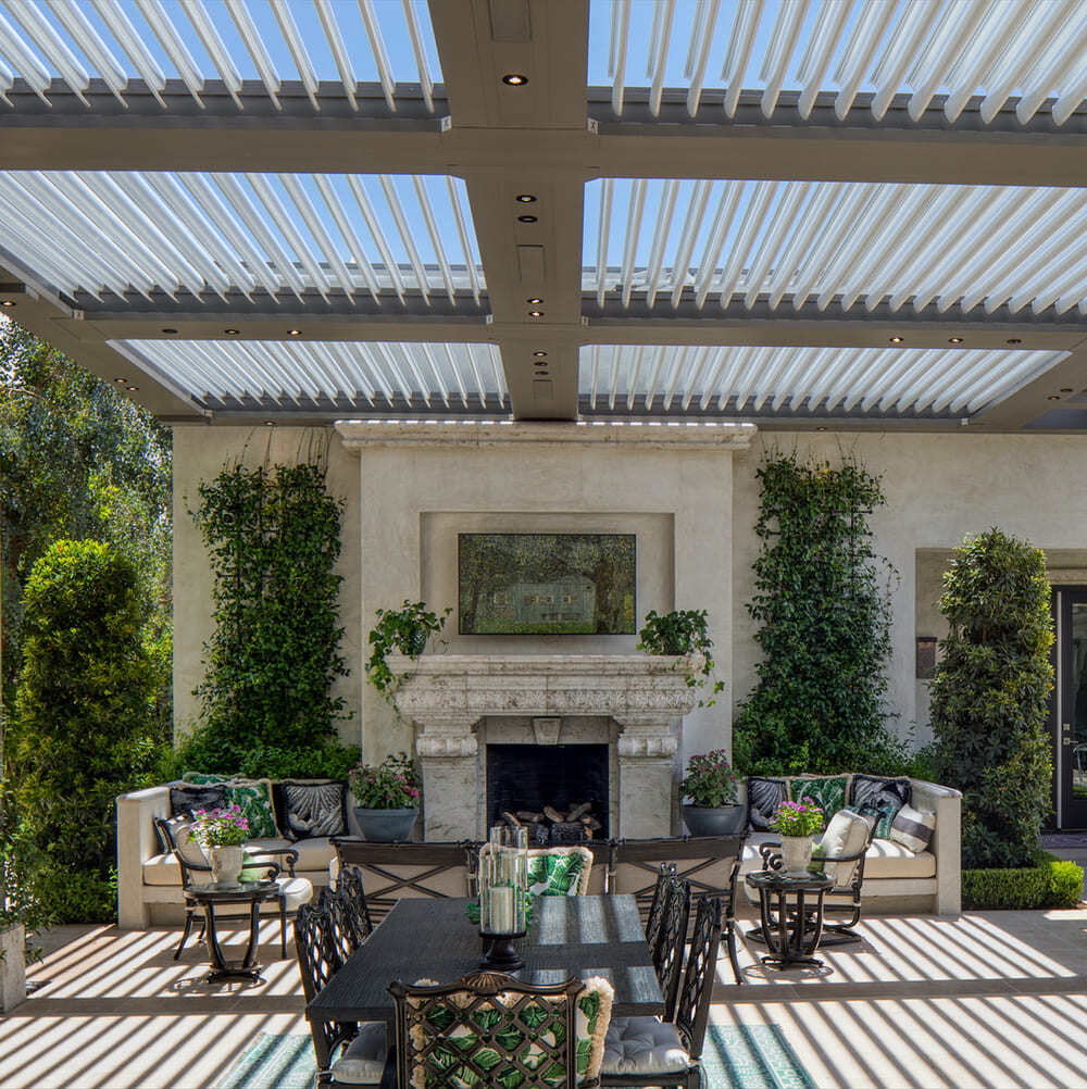 Commercial StruXure pergola above outdoor dining space and fireplace