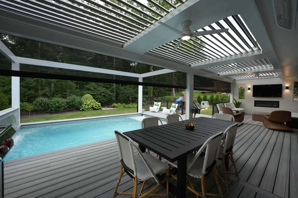 Covered patio struxure pergola with modern dining area and pool, featuring a slatted roof by Deckscapes of Virginia