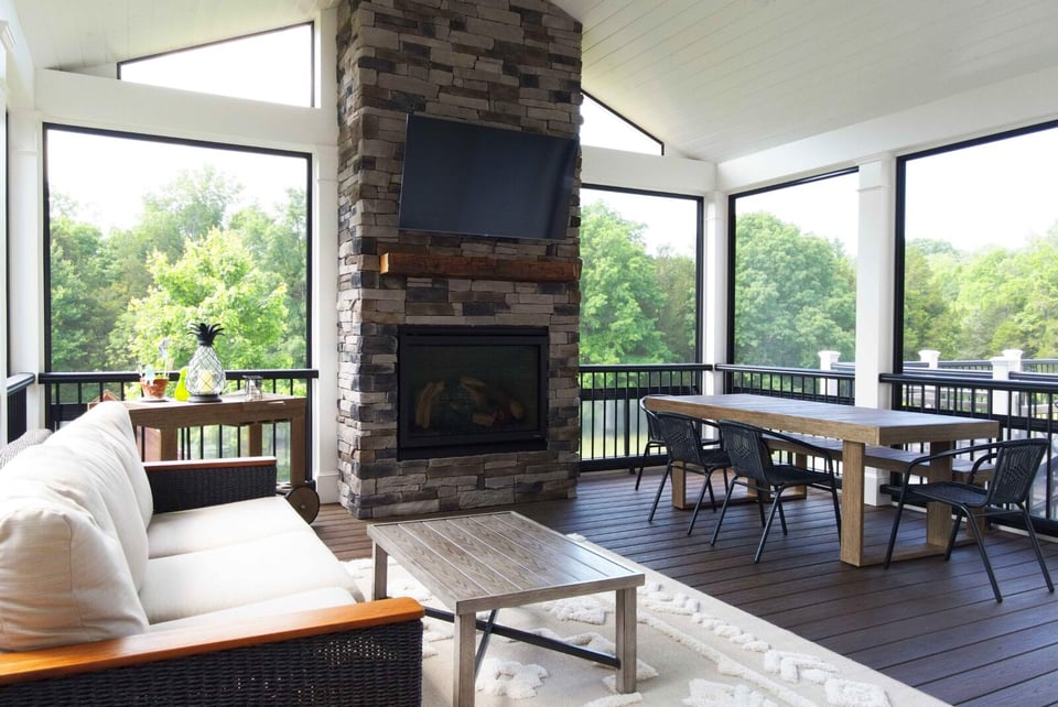 Custom screened in porch with floor-to-ceiling windows and stone fireplace