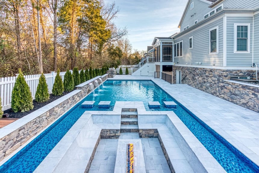 Custom high-end pool by Deckscapes of Virginia with built-in fireplace and seating
