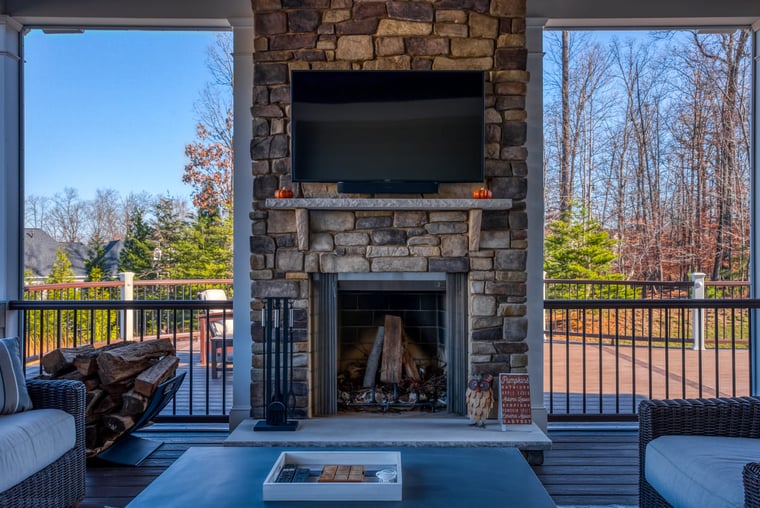 Custom porch by Deckscapes of Virginia with windows beside stacked stone fireplace