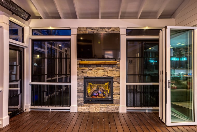 Custom porch interior in Northern Virginia with fireplace and bifold glass doors