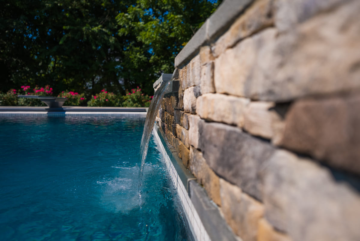 Custom waterfall feature in gunite in-ground pool by Deckscapes of VA
