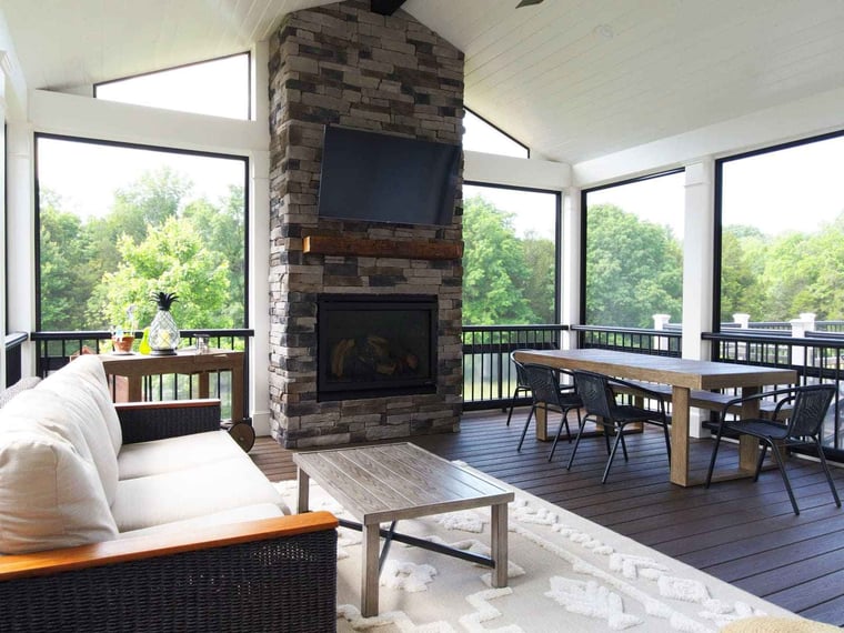 Large covered porch interior with stone fireplace