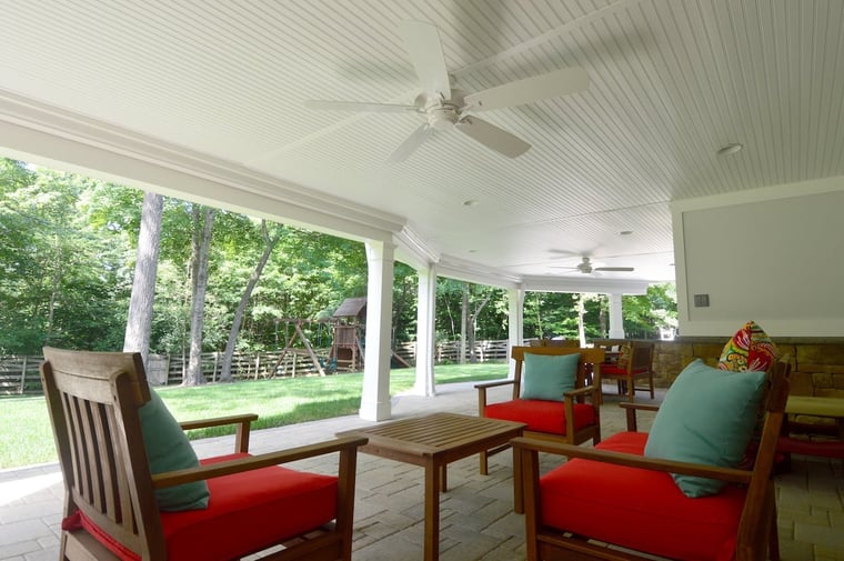 Under deck rain system with ceiling fan and white posts in Northern VA