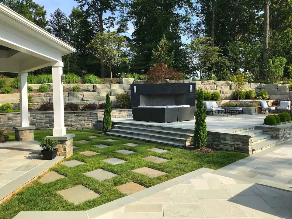 Fireplace and retaining wall on patio with stone walkway
