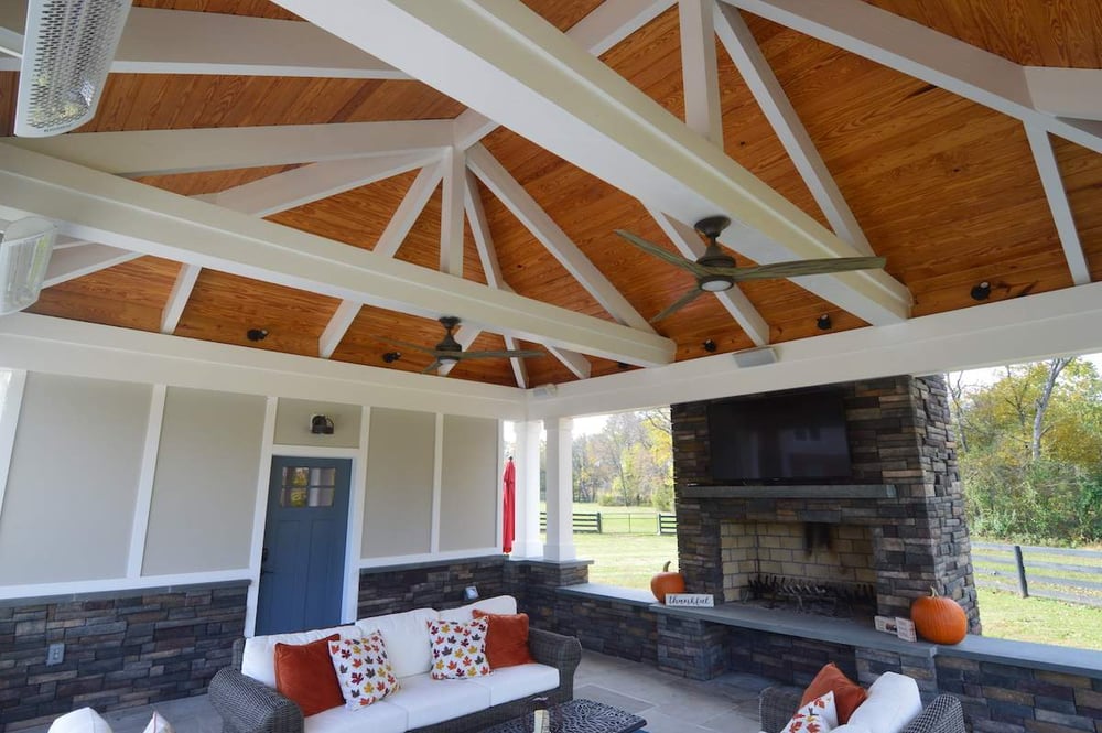 Porch interior with stone fireplace and tv with vaulted ceiling