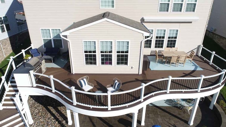 Shot of raised deck with curved white railing with brown deck stain