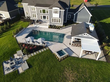 Drone view of round deck with dining, lounging, and barbecue area, designed by Deckscapes of Virginia