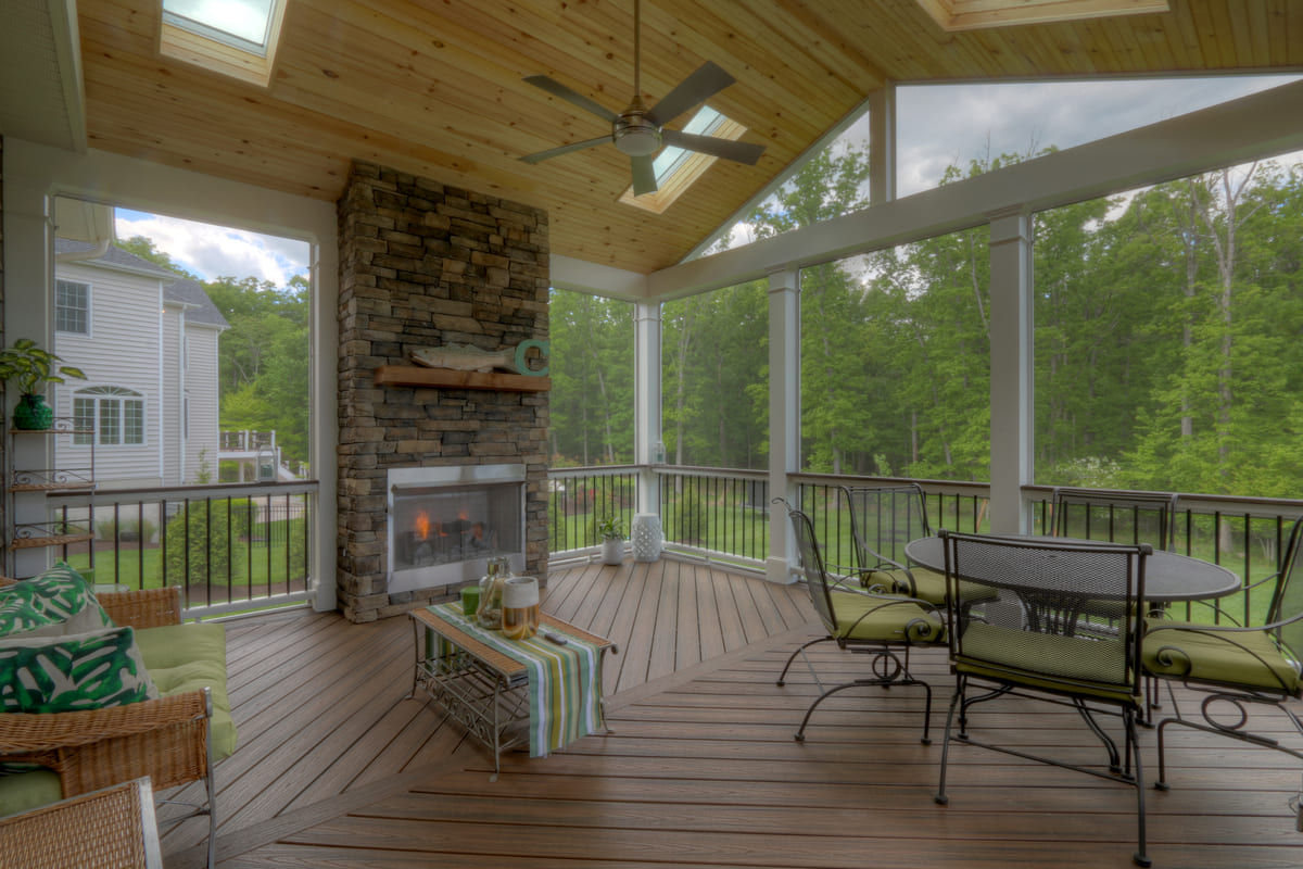 Fireplace on porch with stone veneer surrounding by Deckscapes of Virginia