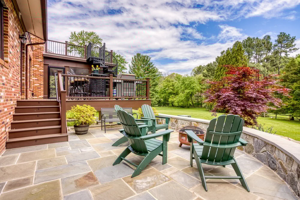 Chairs on patio with steps to multi-level deck by Deckscapes of VA