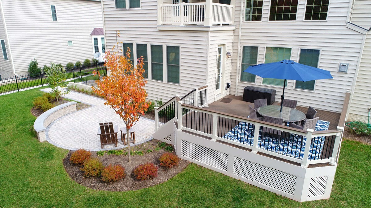 Deck and patio with curved seating wall by Deckscapes of VA