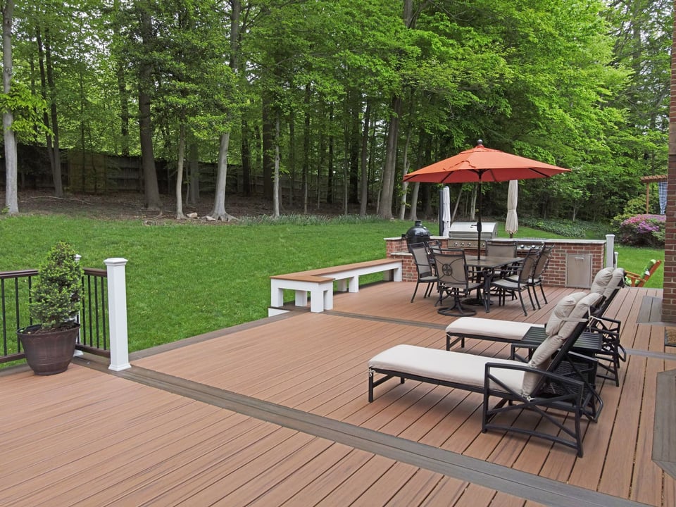 Deck with outdoor kitchen and built-in bench by Deckscapes of Virginia