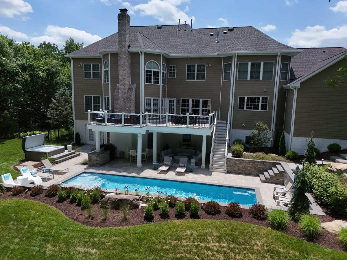 Drone view of pool, patio, and deck by Deckscapes of Virginia