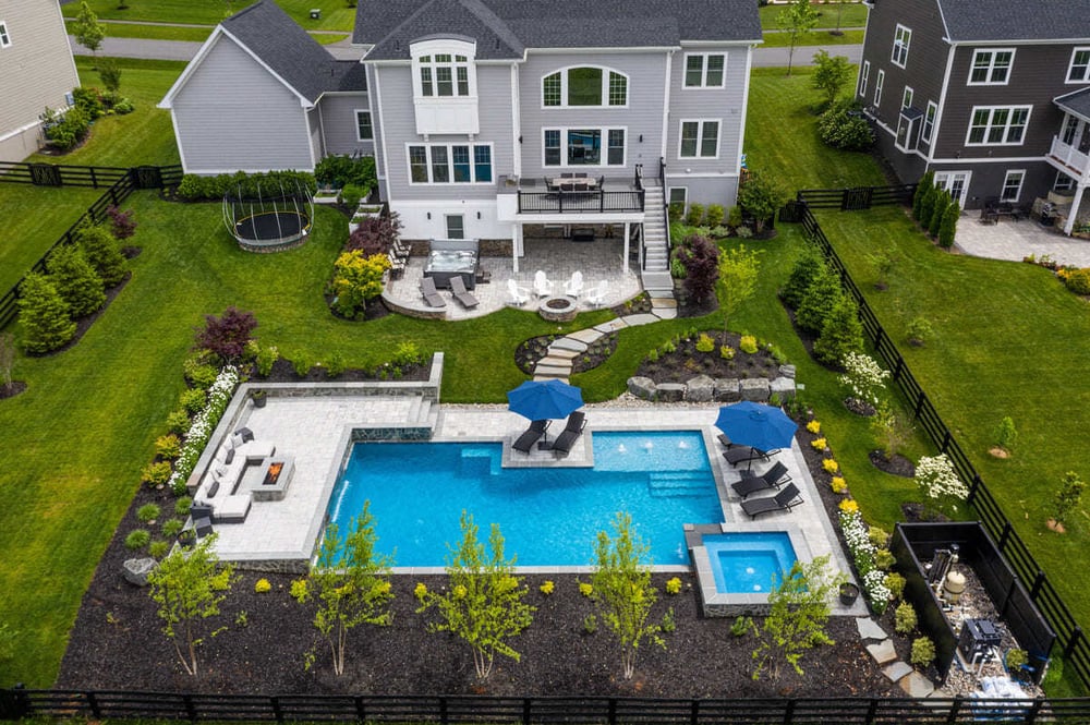 Drone view of pool, patio, and deck design by Deckscapes of VA