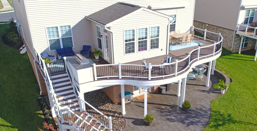 Raised deck with curved design and under deck living space by Deckscapes of VA