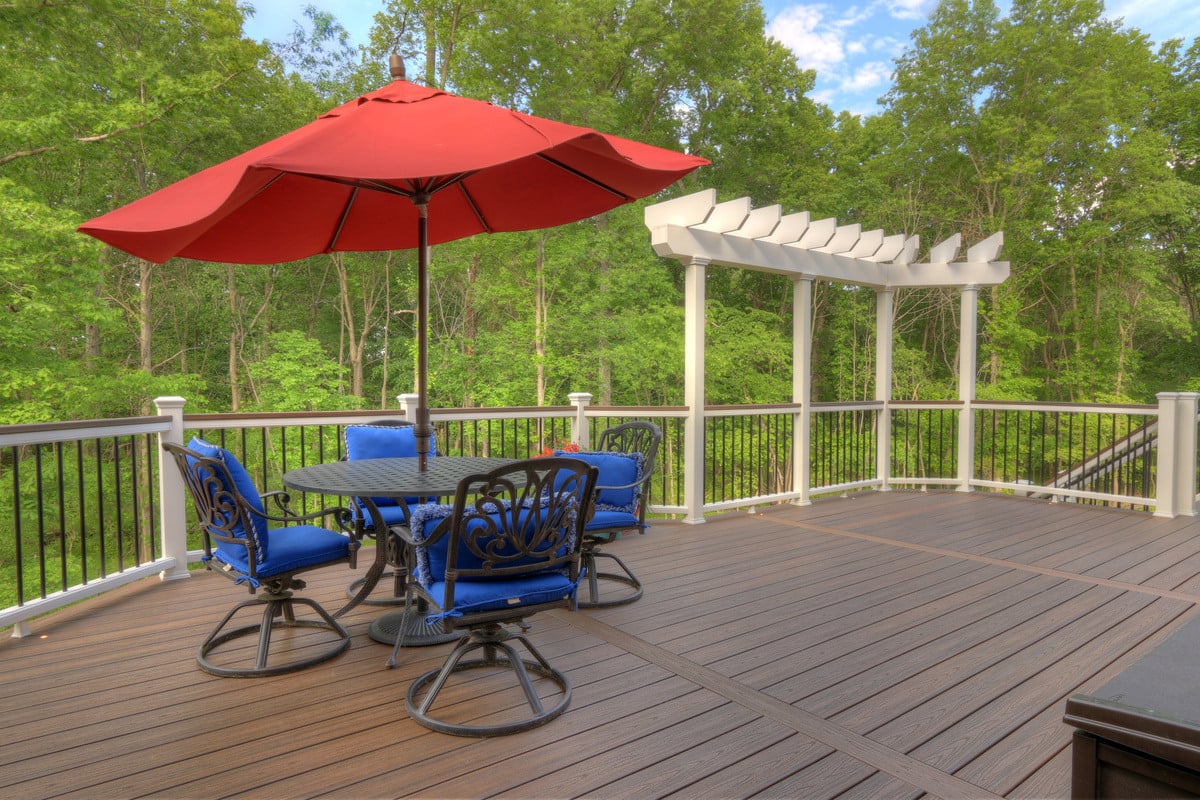 Raised deck with furniture and curved railing by Deckscapes of Virginia