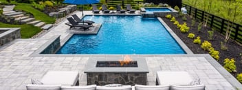 Gunite pool and hot tub with outdoor fire pit and chairs on patio side by Deckscapes of VA