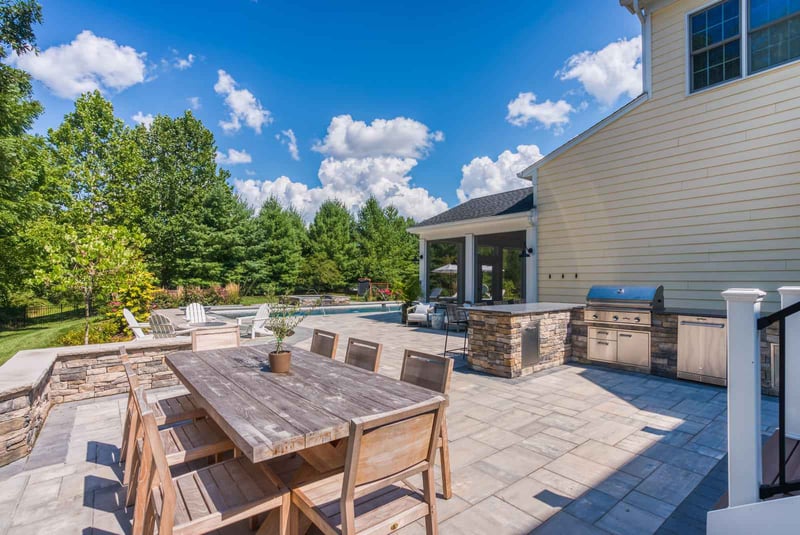 Large backyard stone patio with built in kitchen