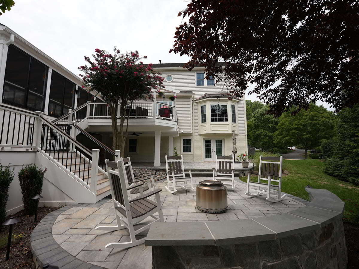 Patio beneath multi-level deck with screened-in porch by Deckscapes of VA