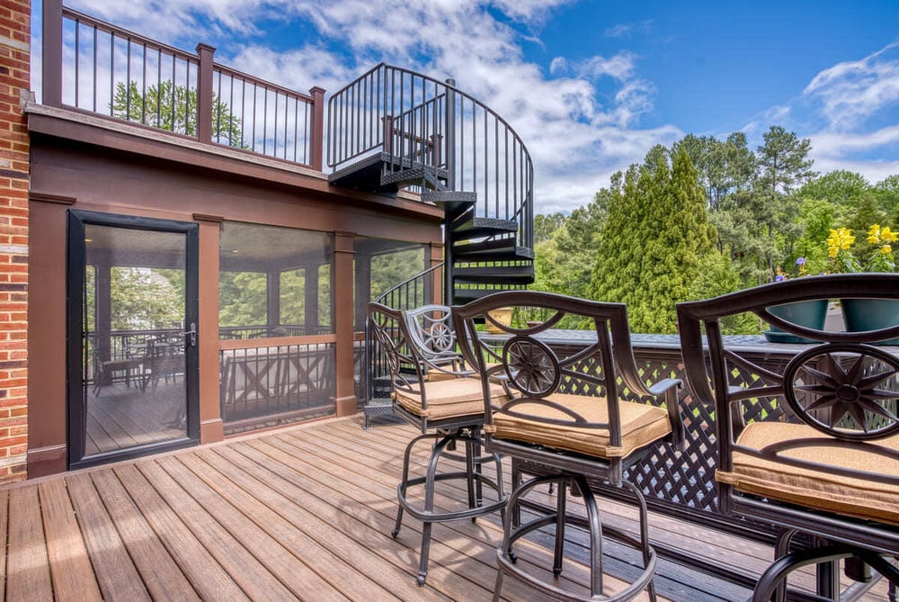 Deck and porch with spiral staircase to upper level by Deckscapes of Virginia