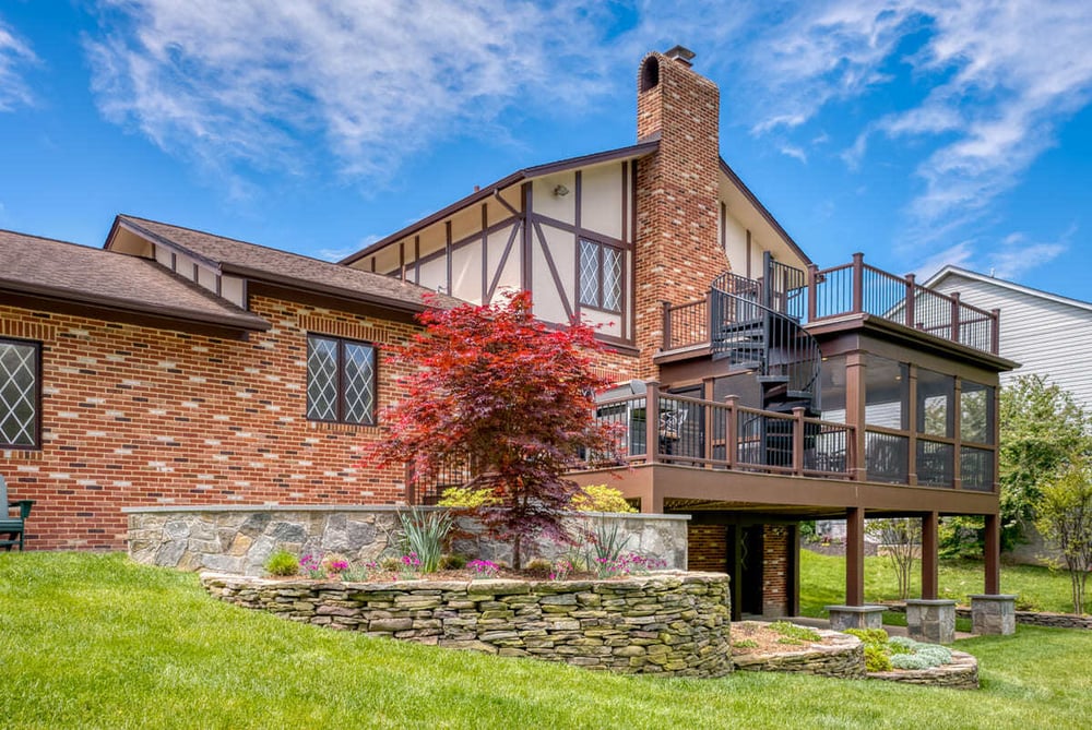 Landscaping around multi-level outdoor living space by Deckscapes of VA