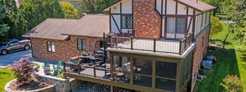 Multi-level deck screened in porch and stone patio in backyard by Deckscapes of VA