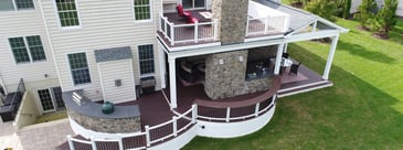 Multi-level curved deck design with outdoor kitchen by Deckscapes of Virginia