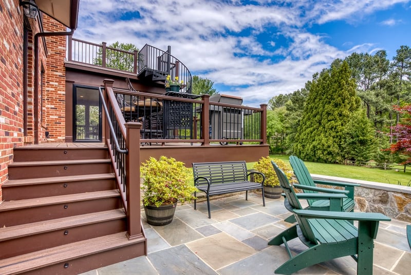 Multi-level deck steps to patio with potted plants by Deckscapes of VA