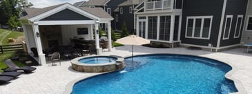 Northern VA outdoor living space with pool, pool house, and patio by Deckscapes of VA