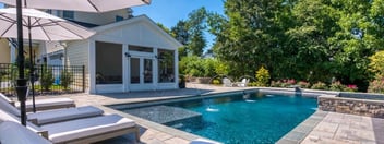 Backyard lounge chairs with in-ground pool and patio by Deckscapes of VA