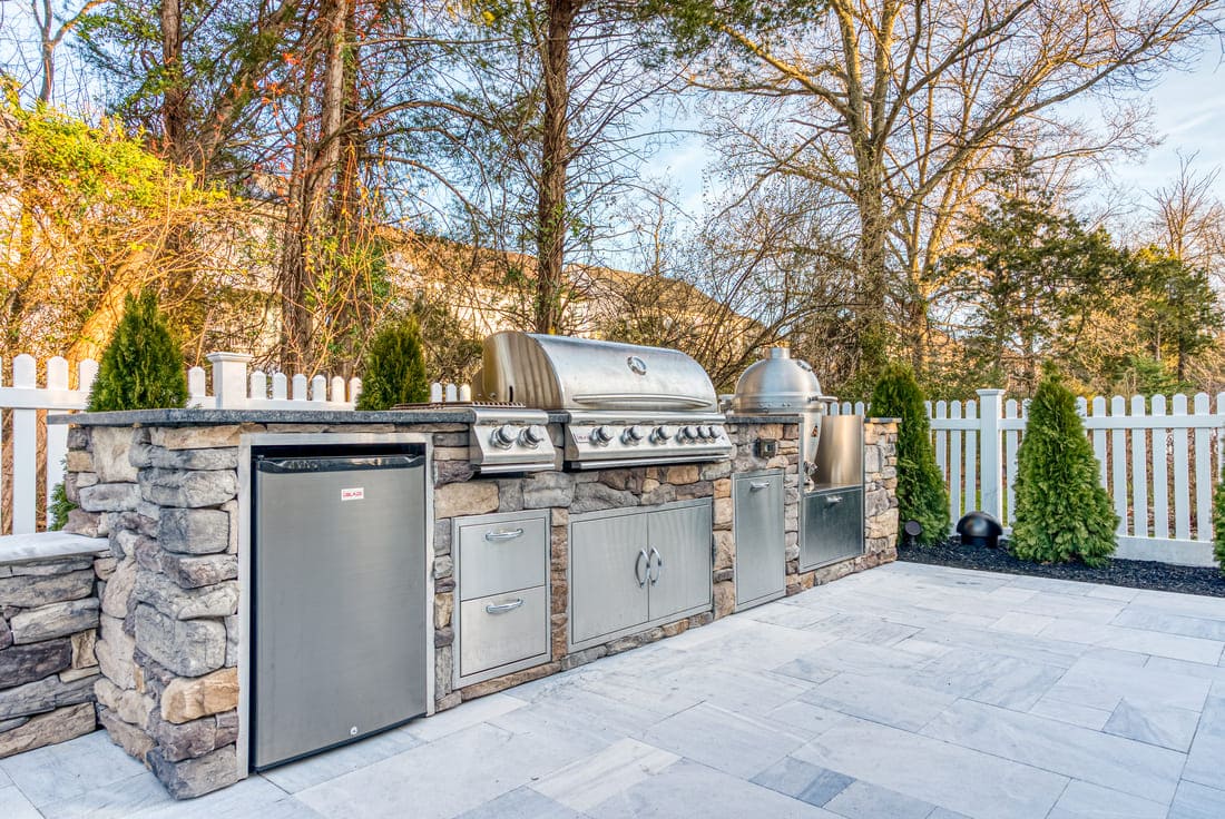 Blaze grill in stacked stone outdoor kitchen on marble patio pavers with smoker by Deckscapes of Virginia