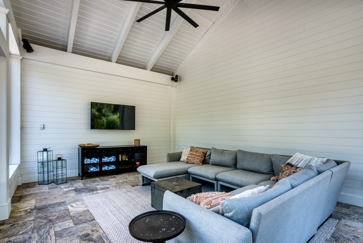 Pool house interior with ceiling fan and TV by Deckscapes of VA 