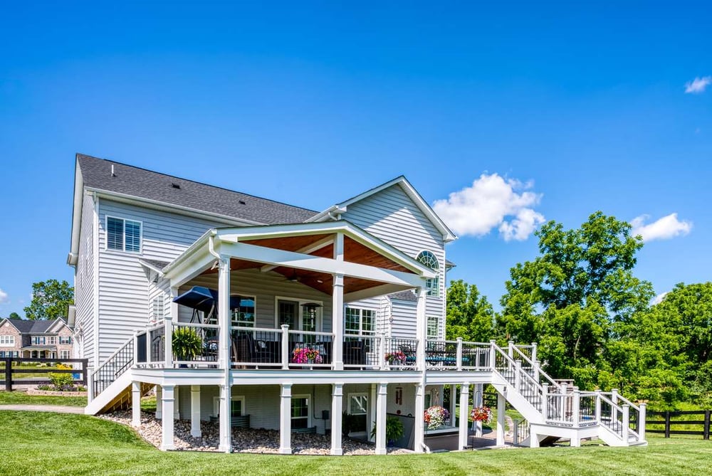 Partially covered raised deck with railing and rain system