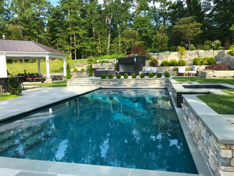 Custom backyard pool on sunny day with hot tub by Deckscapes of VA