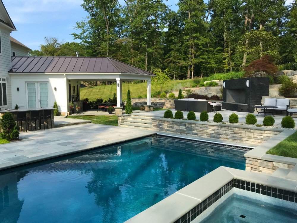 Pool and multi-level patio with covered pavilion by Deckscapes of VA