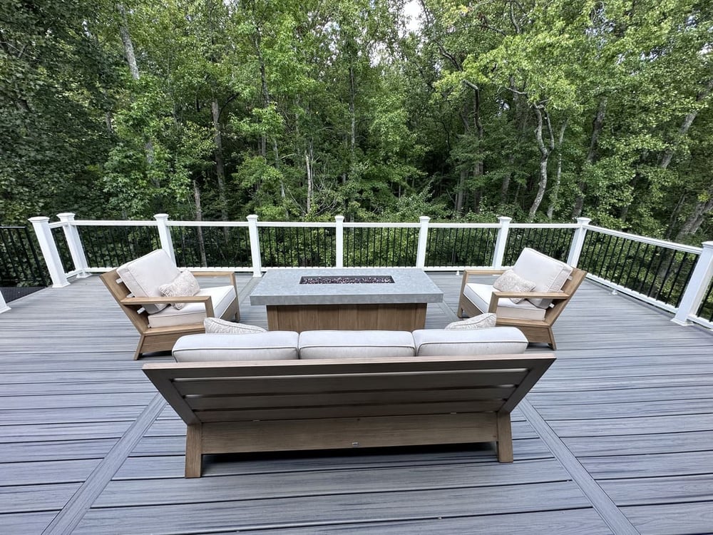 Top story of multi-level deck with fire place and seating by Deckscapes of Virginia