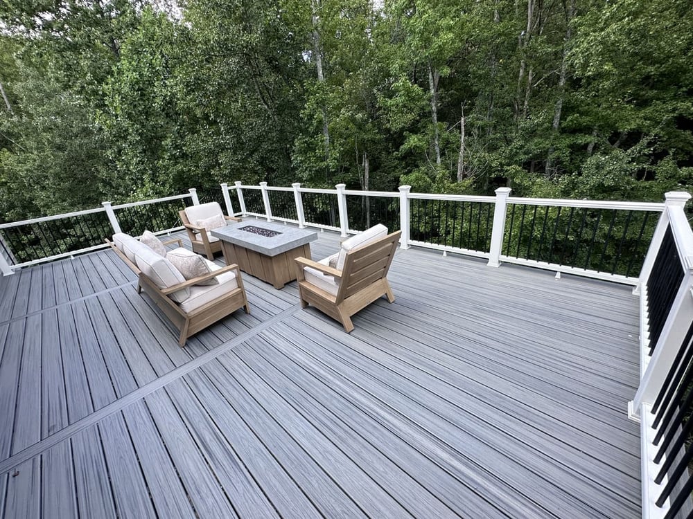 Trex decking and railing on top story of multi-level deck with fireplace by Deckscapes of VA