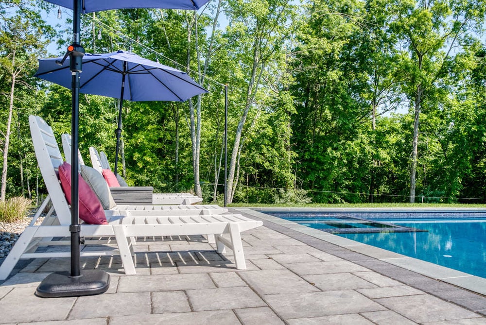 Pool chairs along gunite pool and patio by Deckscapes of Virginia