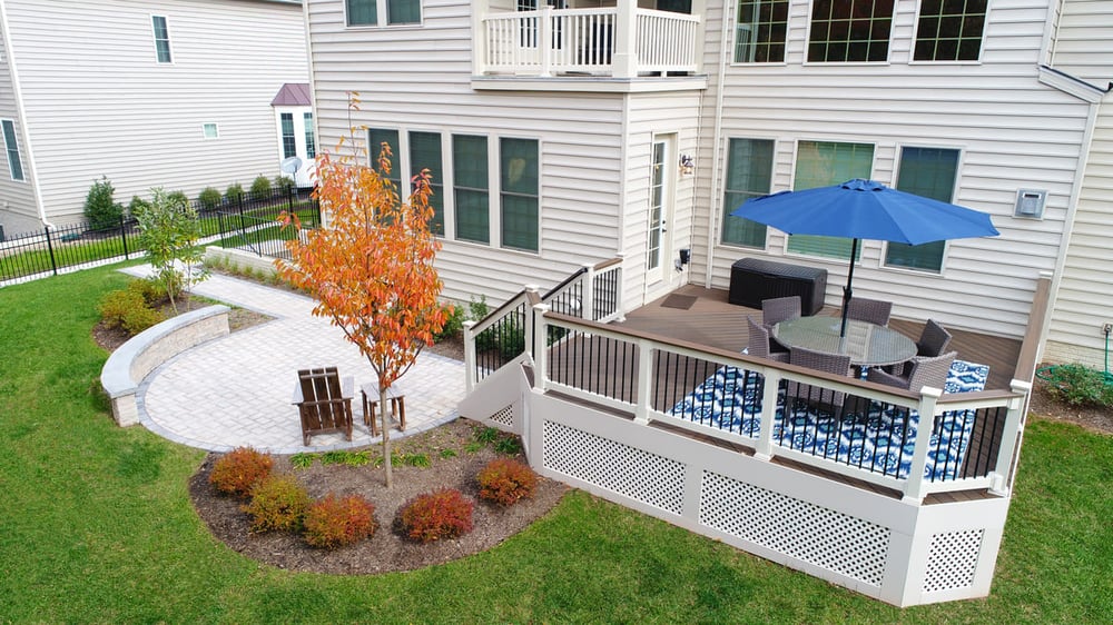 Round paver patio with retaining wall and steps to deck in Northern Virginia